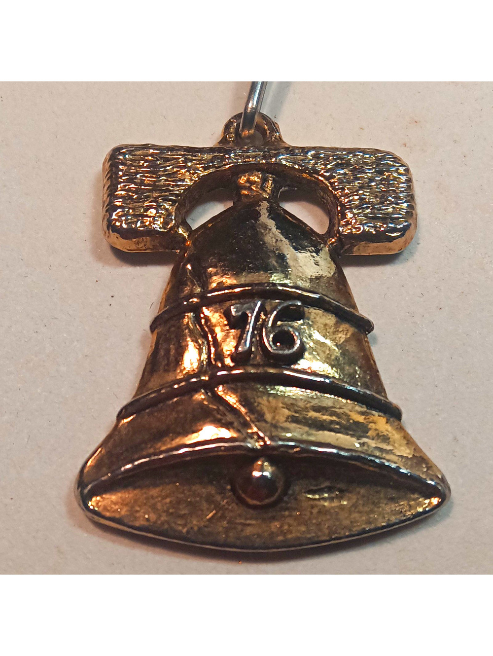 Stamped gold Tone Metal Bell Shape "GOD BLESS AMERICA" on back